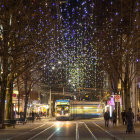 Snowy Christmas Street Scene with Illuminated Buildings and Trees