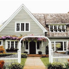 Blue Cottage with White Picket Fence and Vibrant Flowers in Soft Light