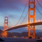 Iconic Golden Gate Bridge at dusk with soft purple skies and reflected lights