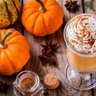 Assorted autumn elements on wooden surface: pumpkins, puree, spices.