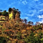 Colorful landscape painting: Path through wildflowers to autumn trees & blue mountains