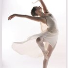 Elegant dancer in flowing dress with illuminated background