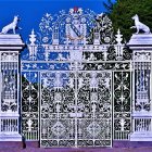 Whimsical blue and white house with ornate windows and wrought-iron fence