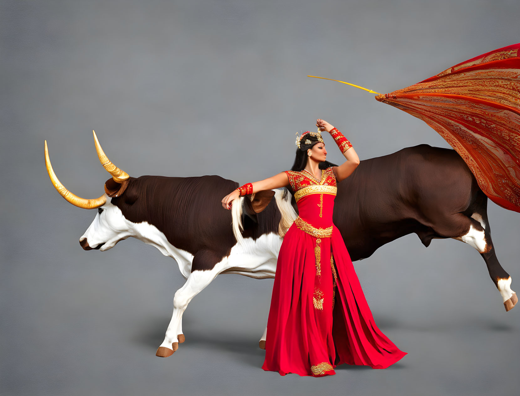 Woman in red and gold traditional outfit with bull horn on gray backdrop.