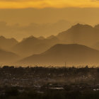 Mountainous Landscape Sunset with Layered Hills & Silhouetted Buildings