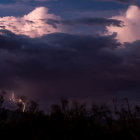 Dramatic night sky with lightning over illuminated stilt houses