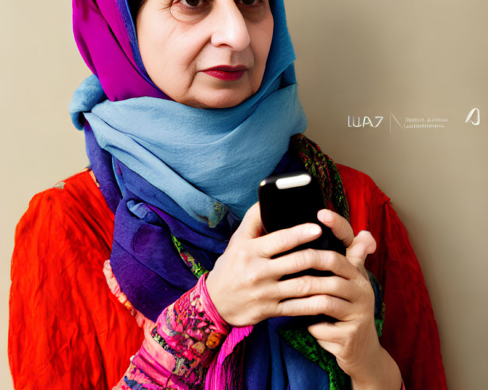 Woman in blue headscarf holding smartphone in orange dress and purple shawl