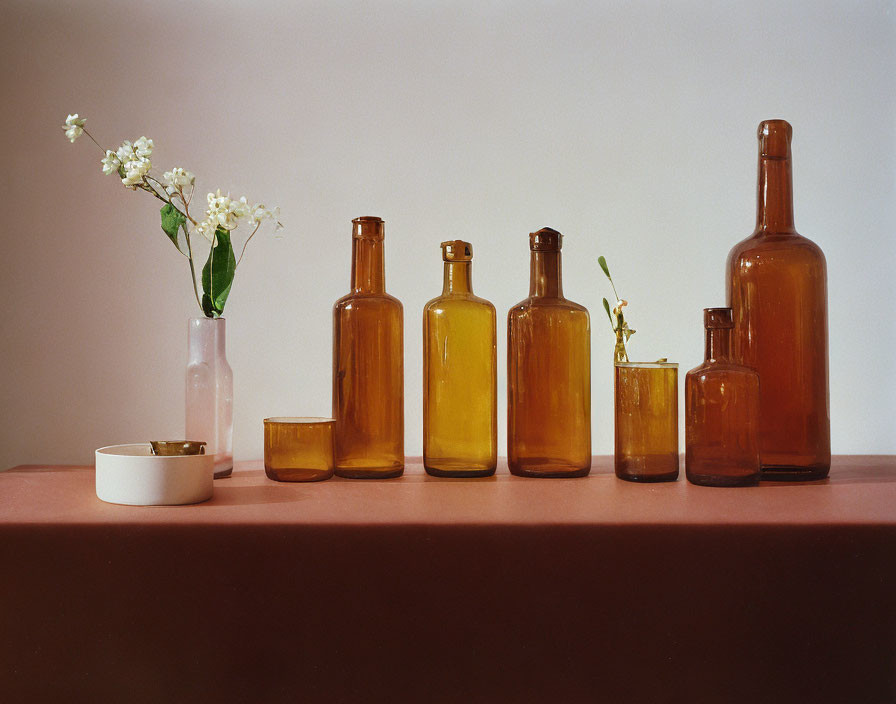 Translucent amber glass bottles with white flowers on table