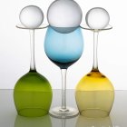 Three elegant glass vases with vibrant flowers on elongated stems against a misty background