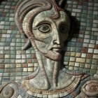 Detailed mosaic sculpture of humanoid face with green eyes