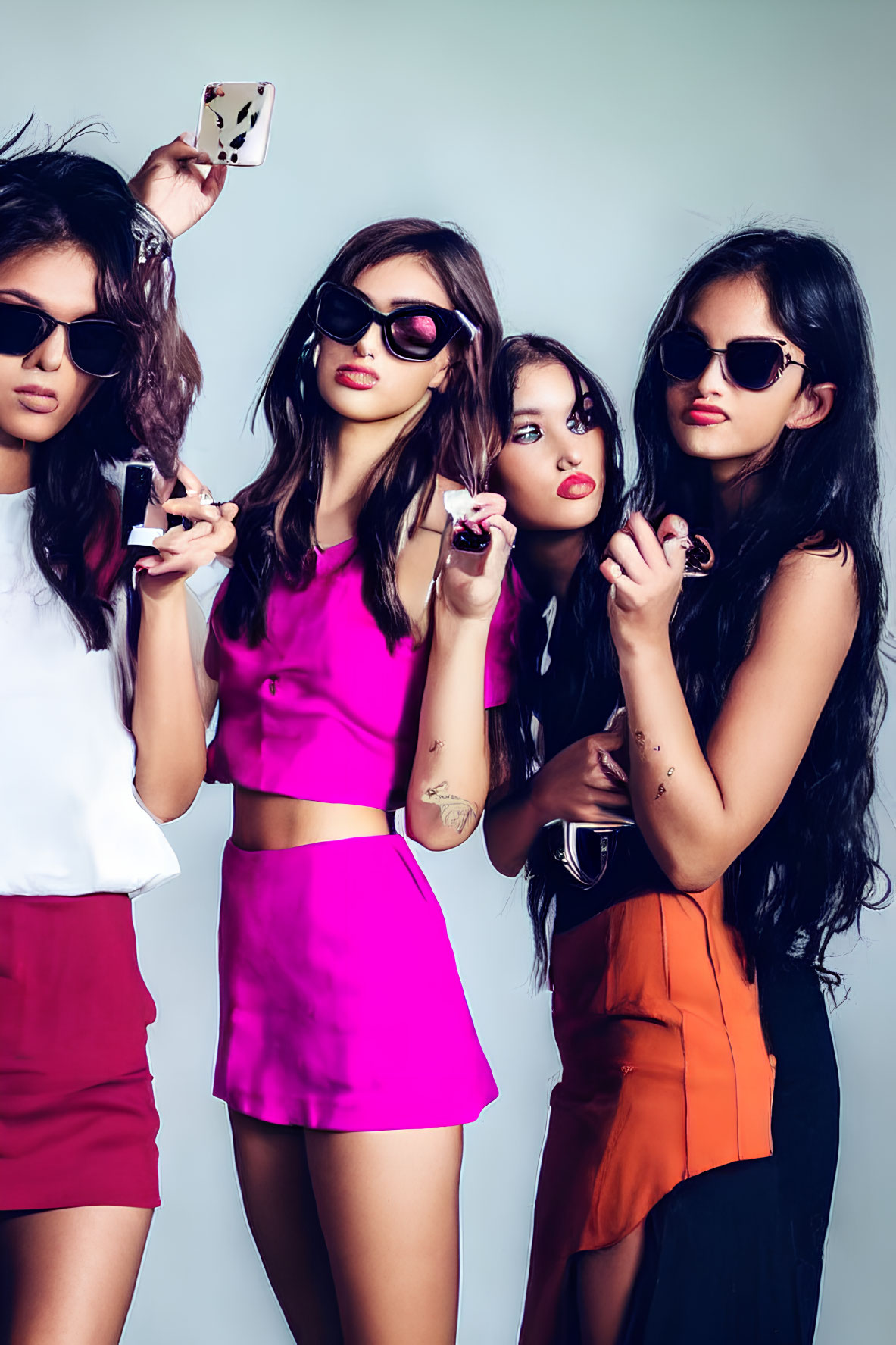 Four women posing stylishly with sunglasses and makeup on grey background