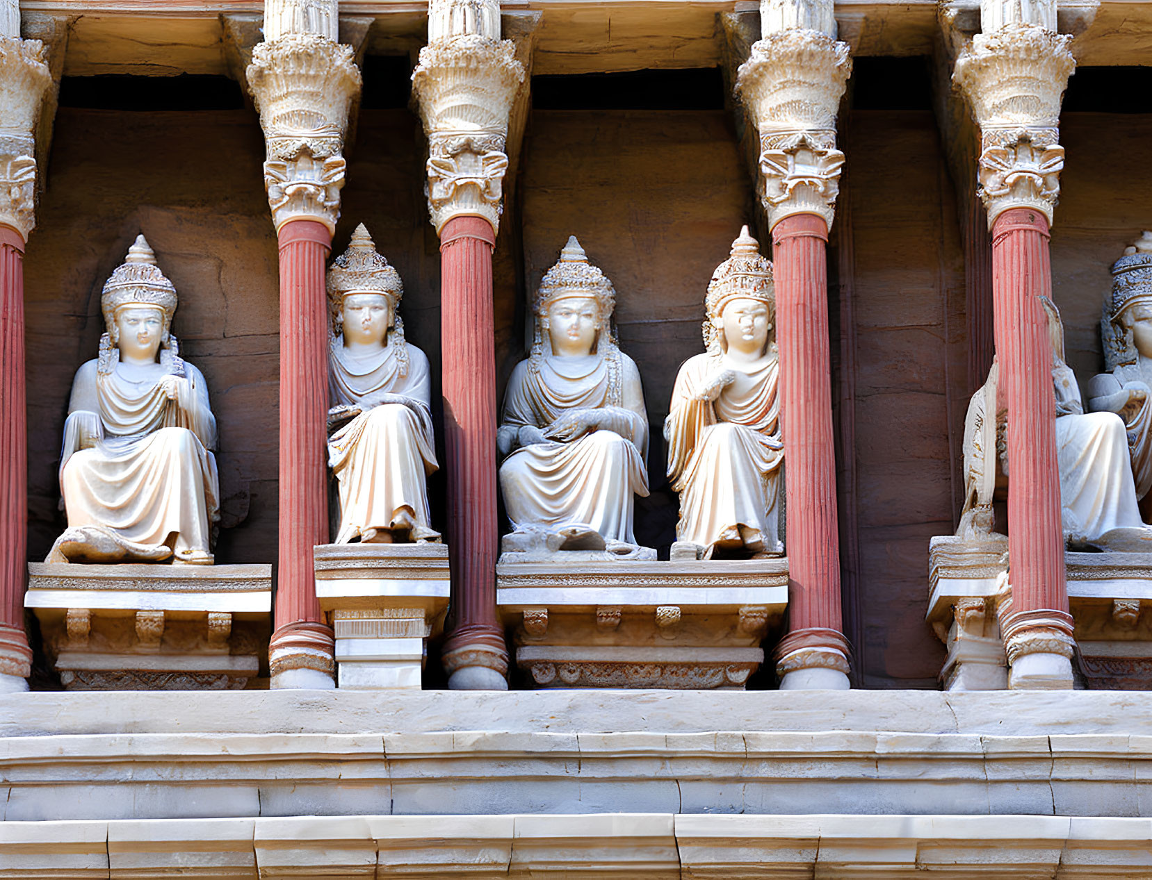 Intricate stone statues of seated figures with ornate columns