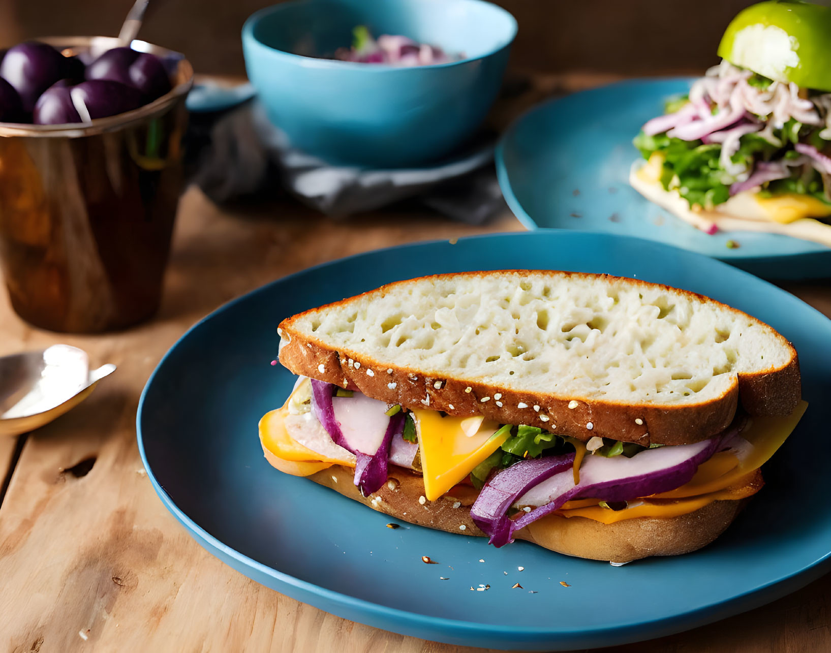 Cheese and vegetable sandwich on blue plate with plums and salad on wooden table