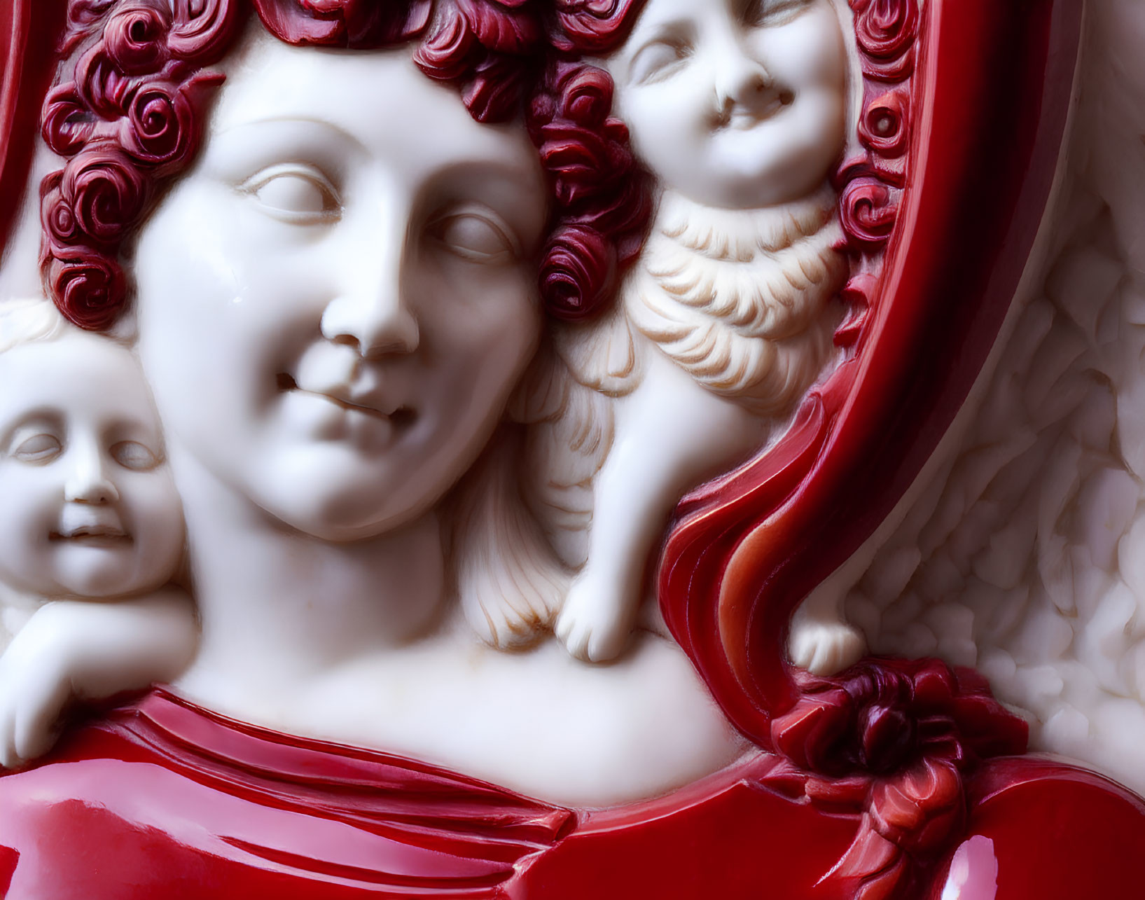 Classical-style sculpture of woman with curly hair and cherubic faces in red and white.