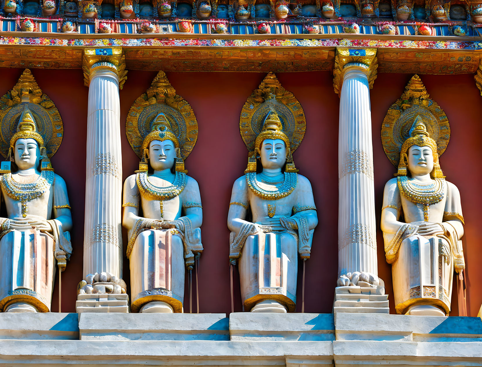 Golden Seated Buddha Statues with Pillars and Colorful Decorations