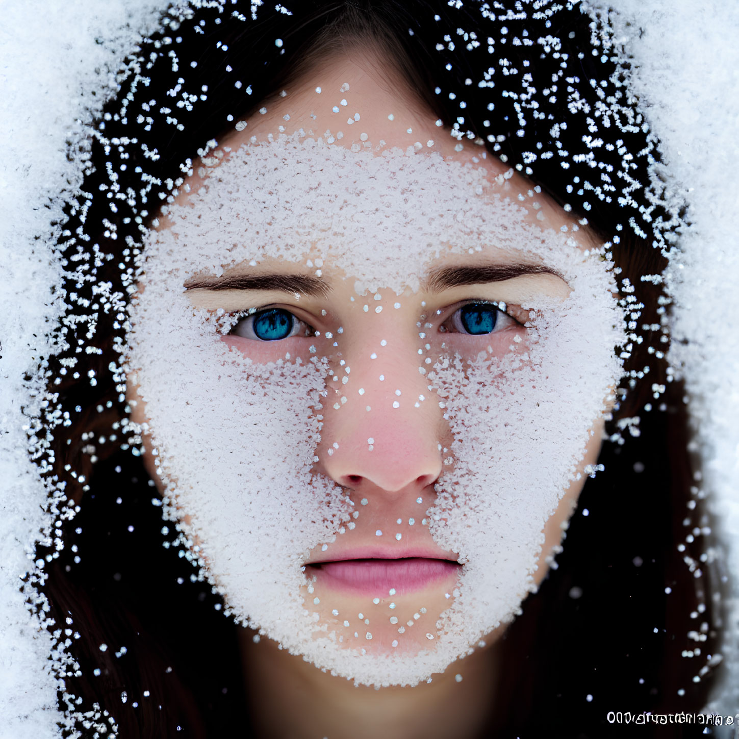 Close-up Portrait of Person Covered in Snowflakes with Clear Blue Eyes