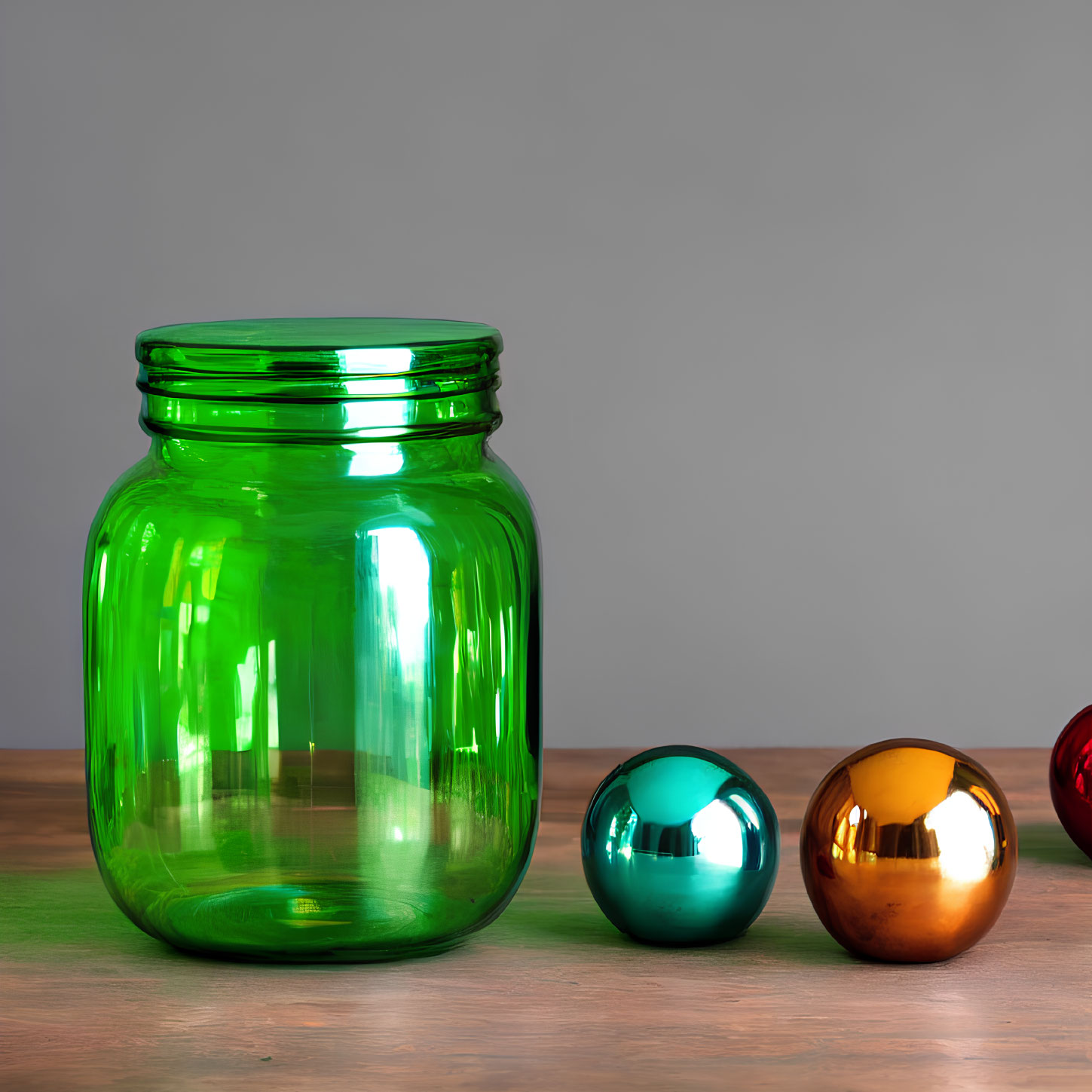 Large Green Glass Jar with Reflective Decorative Spheres on Wooden Surface