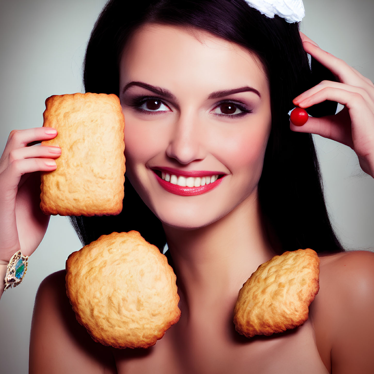 Smiling woman with large pastries, headband, and bracelet