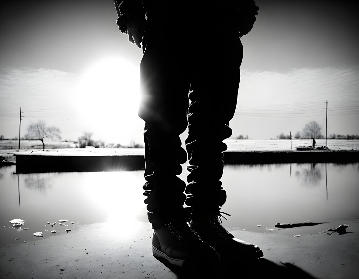 Person's Silhouette by Water with Low Sun Backlight