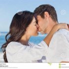 Romantic couple in white embracing on beach backdrop