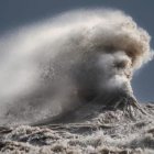 Personified wave with bearded face in stormy sky