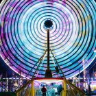 Young person in vibrant futuristic cityscape with circular frame and neon signs