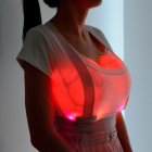 Futuristic woman with glowing red heart in chest surrounded by lights