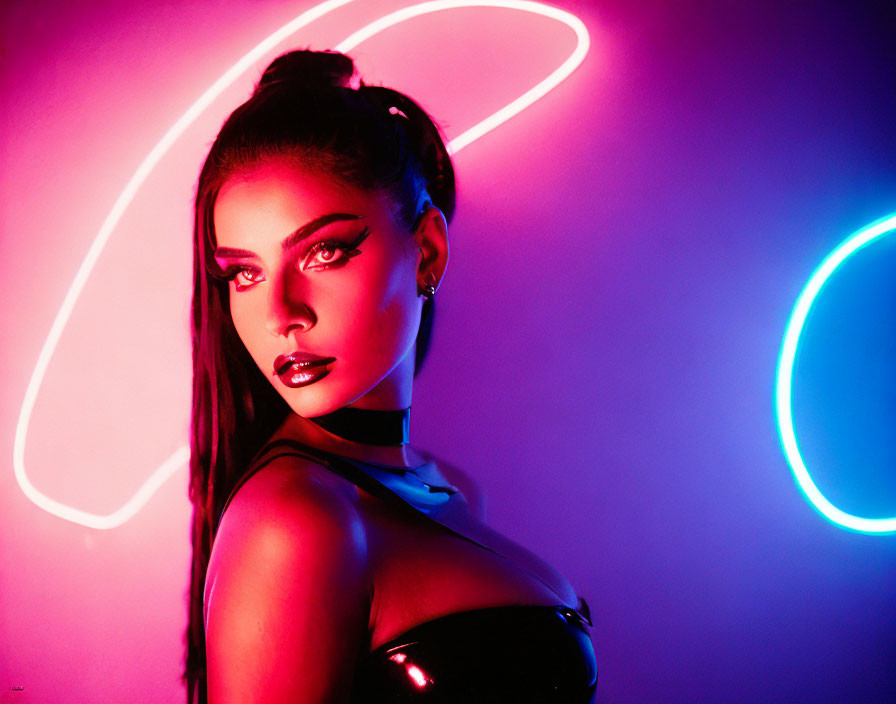 Bold makeup woman poses against vibrant neon background.