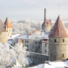 Snow-covered winter village with quaint houses and trees under a soft sky