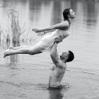 Fantastical swan-human couple embracing by water and golden reeds