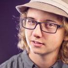 Stylish Woman with Glasses and Hat in Soft Purple Background