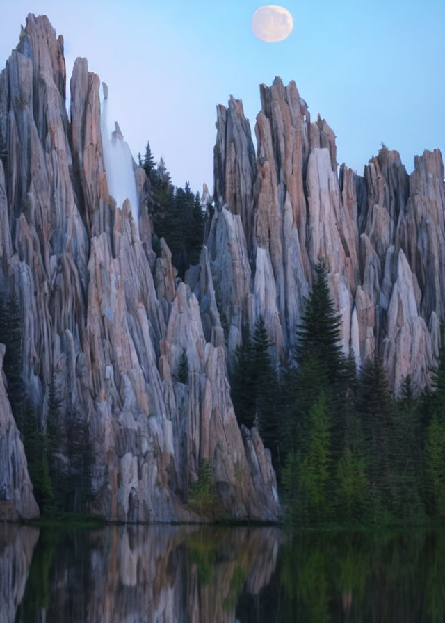 Rock formations and forest reflected in still water under a dusk sky with full moon.