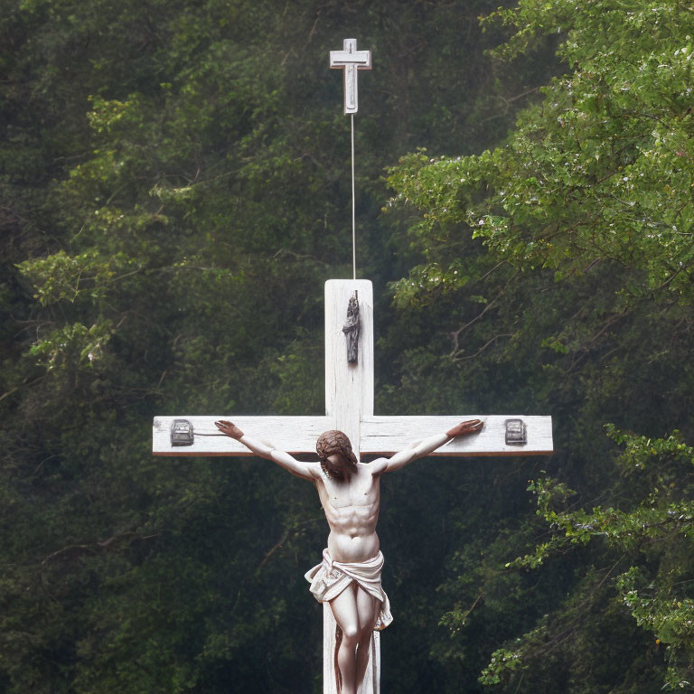 Statue of Jesus Christ on Cross Surrounded by Green Trees