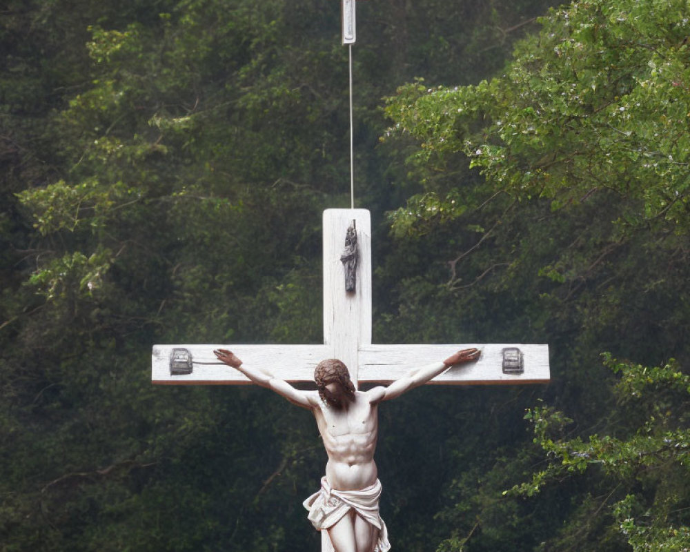 Statue of Jesus Christ on Cross Surrounded by Green Trees