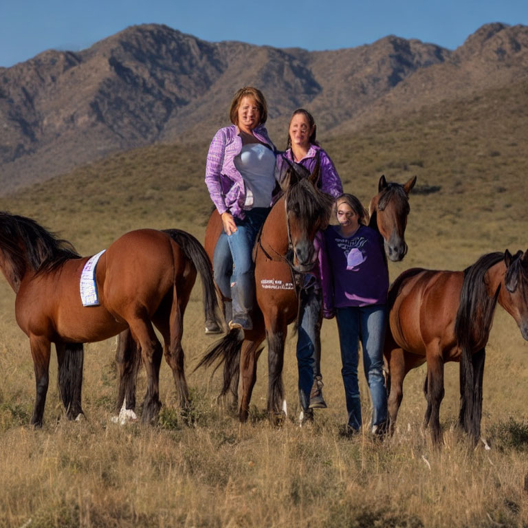 Group of Three People Posing with Four Horses in Field