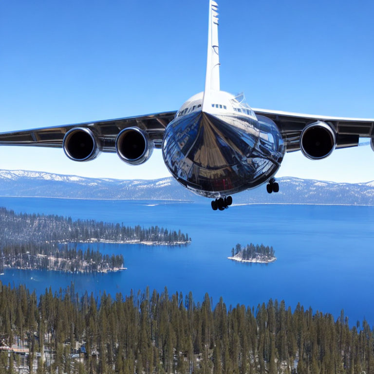 Low-flying airplane over serene lake and forest landscape