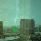 Neon-blue tower struck by lightning in ancient setting under green-tinged sky