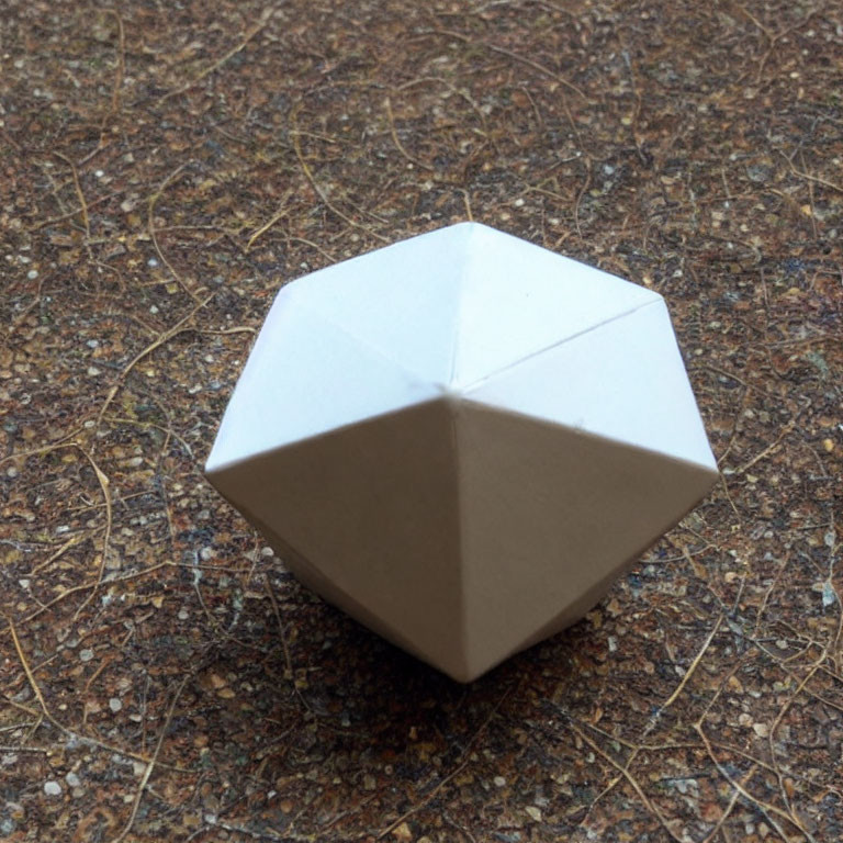 White Origami Octahedron on Textured Brown Surface