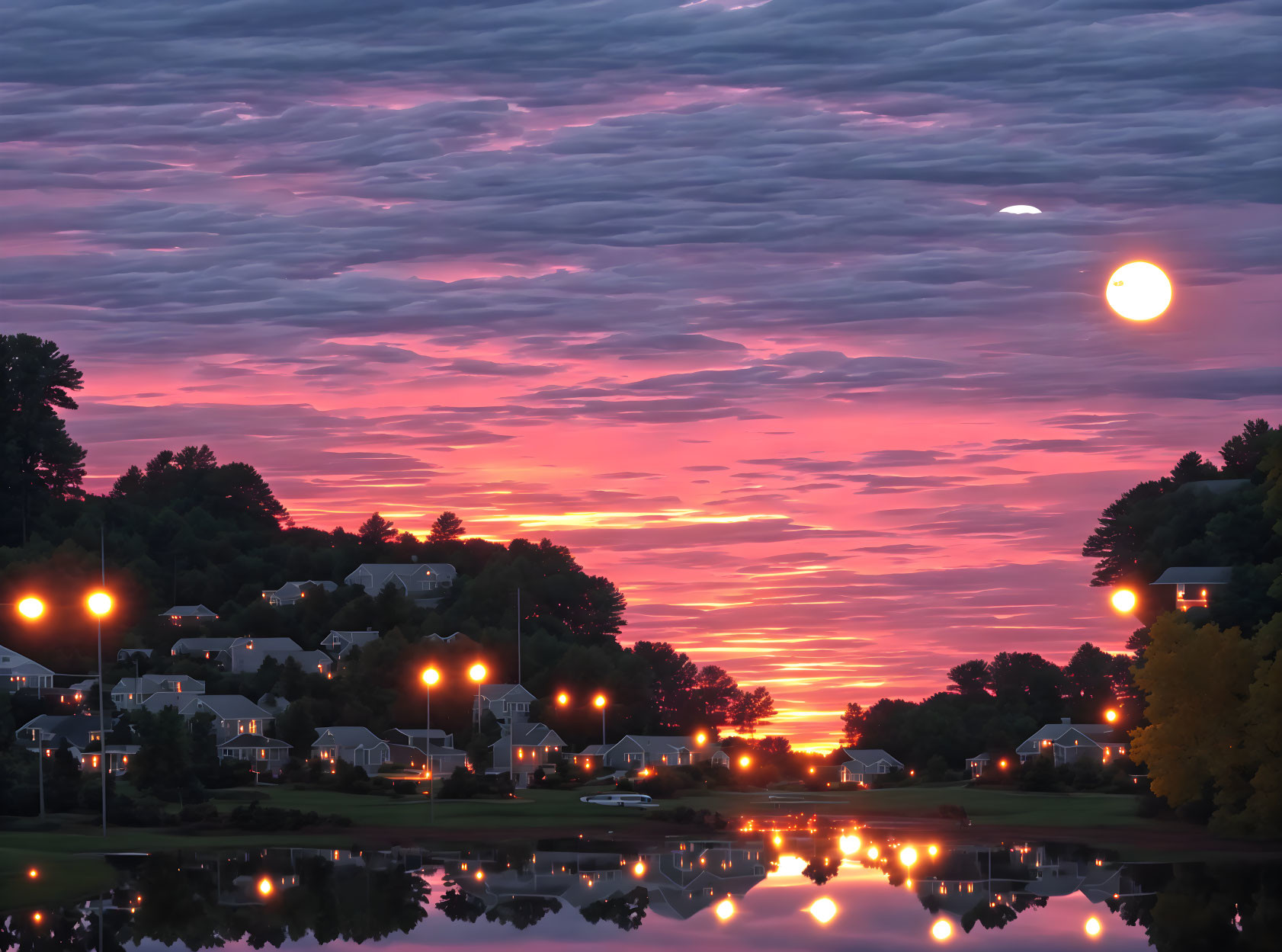 Tranquil sunrise over calm lake in sleepy town at dawn