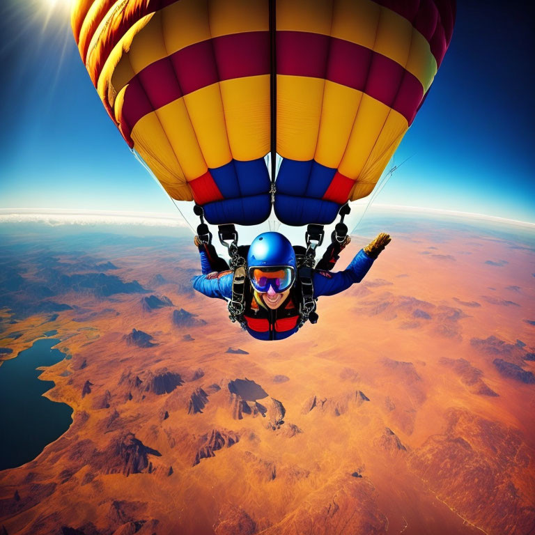 Person in blue jumpsuit skydives above desert with hot air balloon