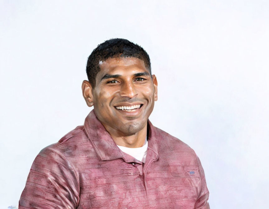 Smiling man with short haircut in pink shirt on light background