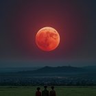 Three individuals under surreal red moon in night field