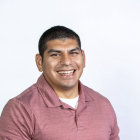 Smiling man in red hoodie against white background