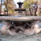 Tranquil park scene with stone fountains and lush trees