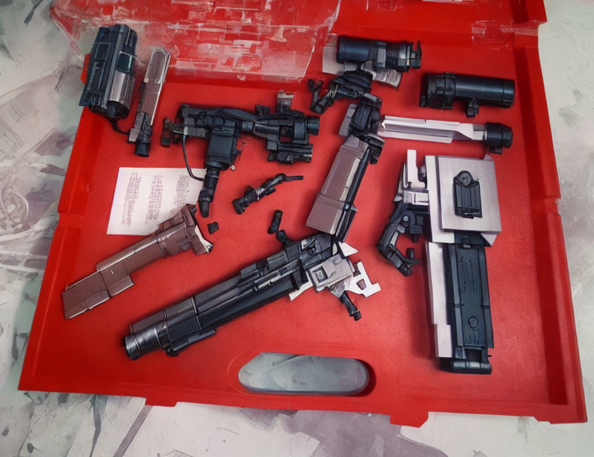 Collection of Plastic Toy Guns and Weapons on Red Tray