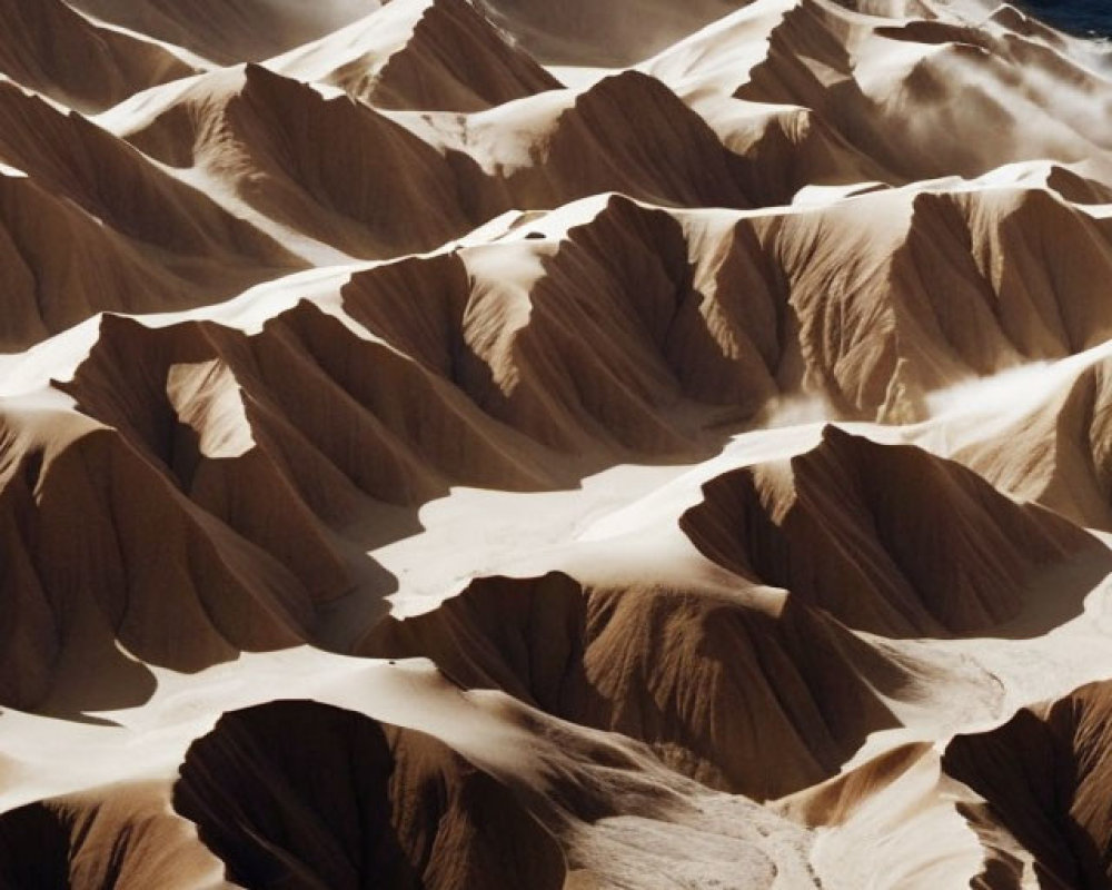 Sand dunes with sharp peaks and valleys near a coastline.