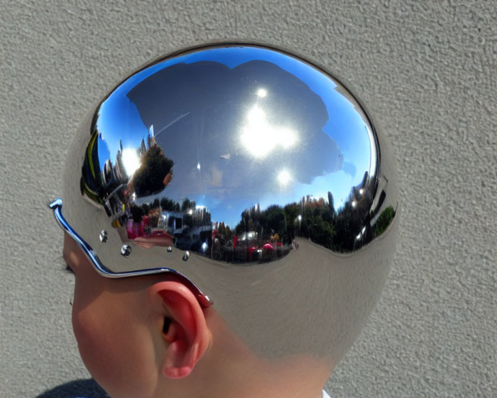 Child wearing reflective helmet blending with environment, trees, cars, and sun.