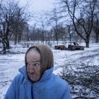 Child with dramatic crack-like makeup in desolate landscape.