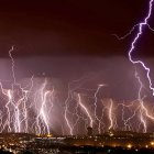 Futuristic night cityscape with skyscrapers, spaceship, lightning bolt