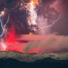 Apocalyptic landscape with crimson sky and lightning strike